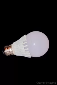 Photograph of a single LED light bulb on its side on a black background by Cramer Imaging