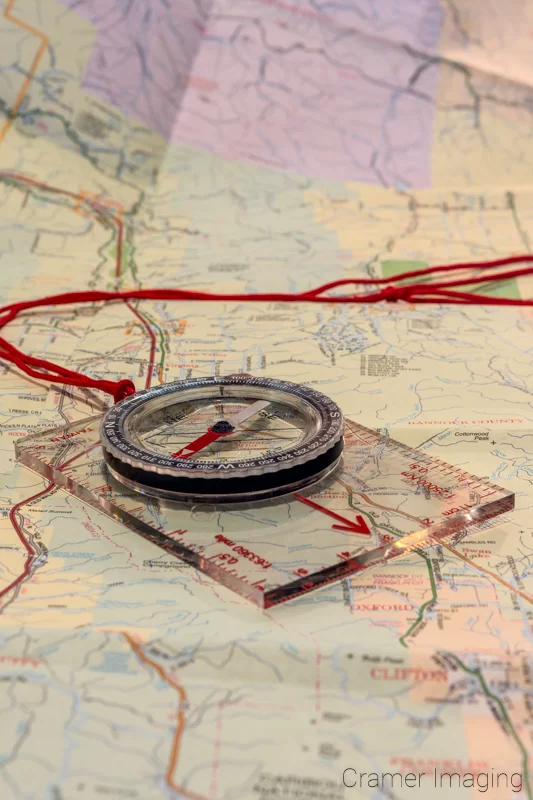 Map and Compass Photo Audrey Cramer Photography's professional quality stock photograph of a map and direction-finding compass laid out on top