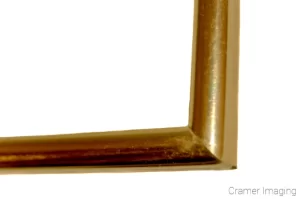 Cramer Imaging's photograph of a single gold colored metal picture frame corner on a white background