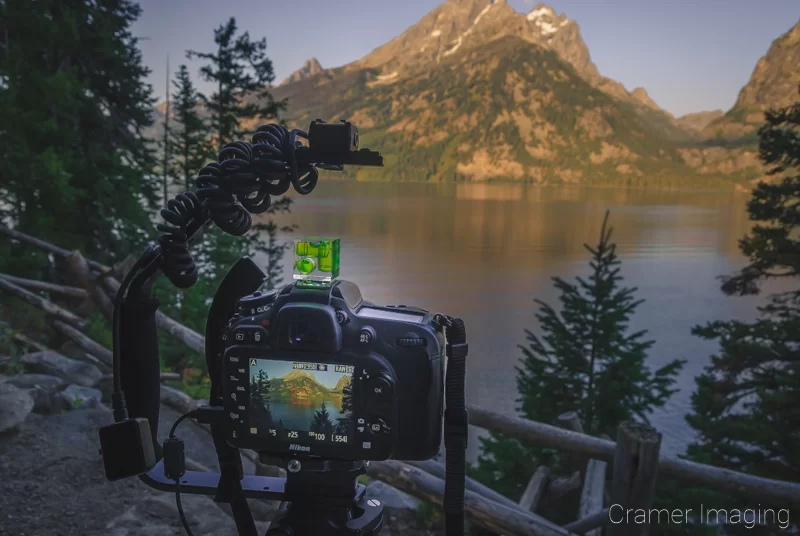 Audrey Cramer Photography's photograph of a camera on a tripod taking a lake picture at Grand Teton National Park Wyoming at sunrise