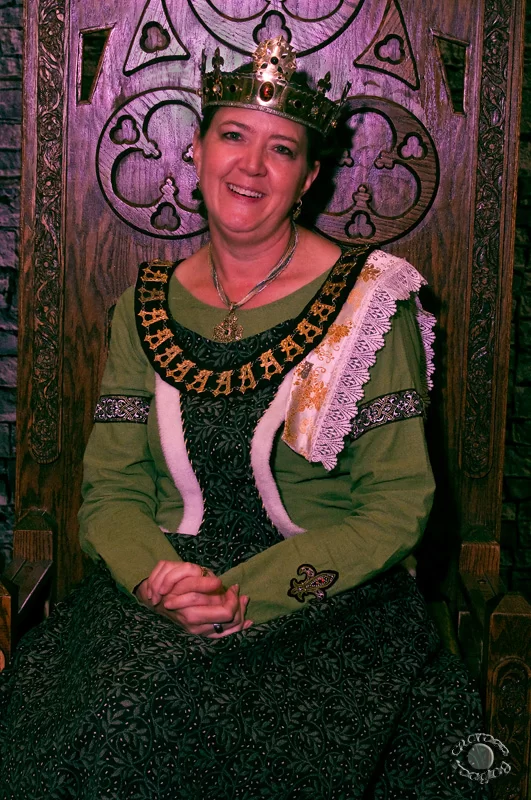 portrait of a woman wearing a crown sitting on a throne