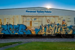 Photograph of a potato processing plant with railroad car in front and sunburst in Aberdeen Idaho by Cramer Imaging