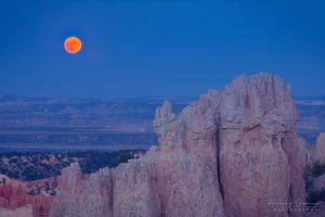 Audrey Cramer Photography's fine art landscape closeup photograph of a red moon rising over a rock formation of Bryce Canyon National Park Utah