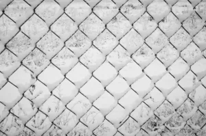 Professional quality fine art photograph of a snow-covered chain link fence