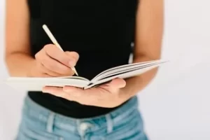 Picture of a woman taking notes in a notebook