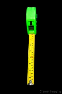 Cramer Imaging's professional quality stock photograph of a yellow and green tape measure on a black background