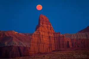 Cramer Imaging's professional landscape photograph of a red moon rising over the Temple of the Moon in Capitol Reef National Park Utah