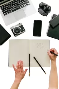 Picture of a to-do list on a desk with electronics present