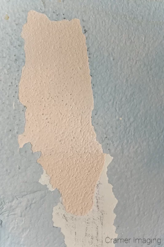 Audrey Cramer Photography's photograph of a dirty and damaged wall example with peeling light blue paint