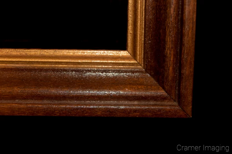 Audrey Cramer Photography's photograph of a single brown wooden picture frame corner on a black background