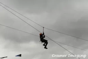 Cramer Imaging's photograph of an outdoor enthusiast on a zip line against the sky in Firth, Idaho