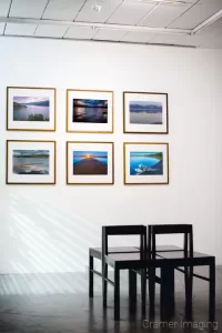 Cramer Imaging's photograph of six framed landscape photographs from the Grand Teton Council Collection on a gallery wall