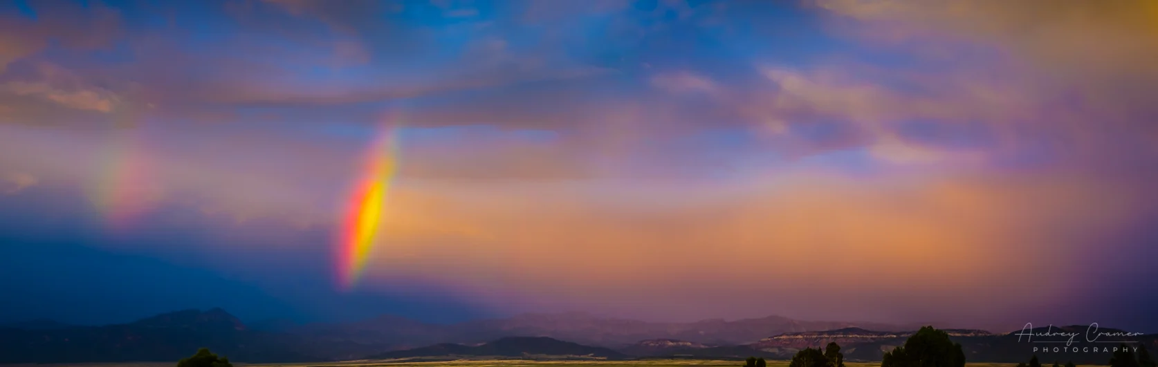 Audrey Cramer Photography's fine art landscape photograph of a double rainbow arc against a dramatic sunset sky in Panguitch, Utah