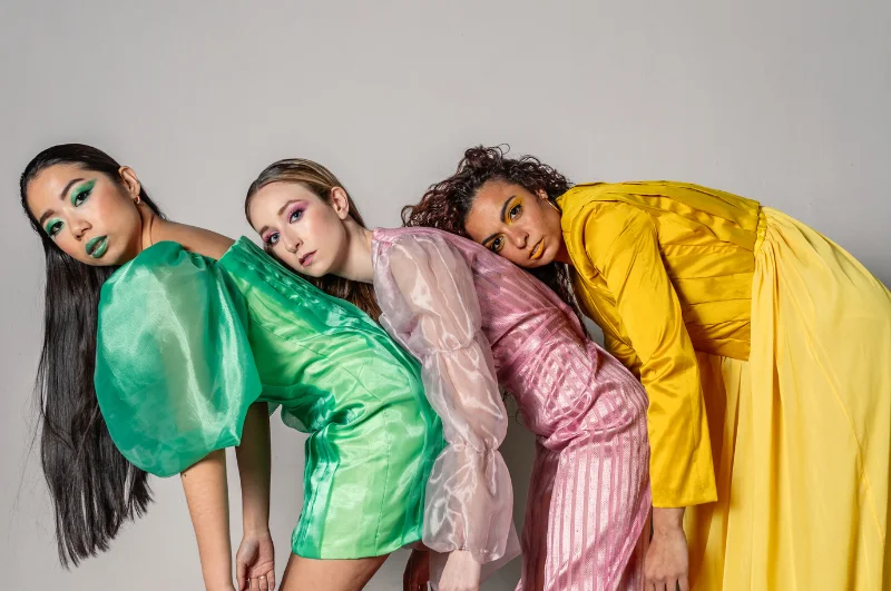 Women dressed up in fancy dresses for a fashion shoot