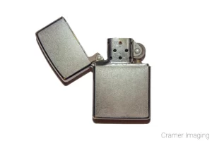 Photograph of a fire starting Zippo lighter on a white background