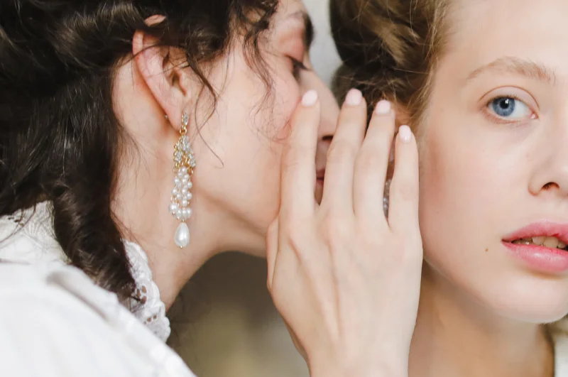 Two women whispering and sharing a secret