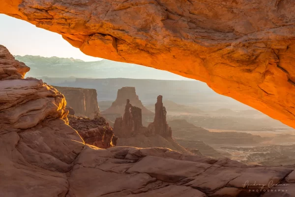 Audrey Cramer Photography's fine art landscape photograph of the Washer Woman arch seen through Mesa Arch at sunrise in Canyonlands National Park, Utah