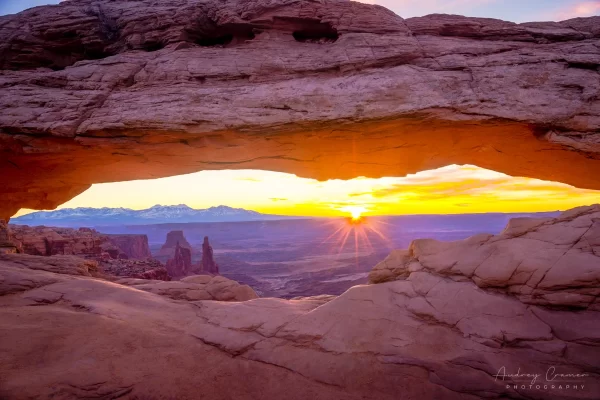 Audrey Cramer Photography's fine art landscape photograph of the sun bursting over the horizon at sunrise at Mesa Arch, Canyonlands National Park, Utah