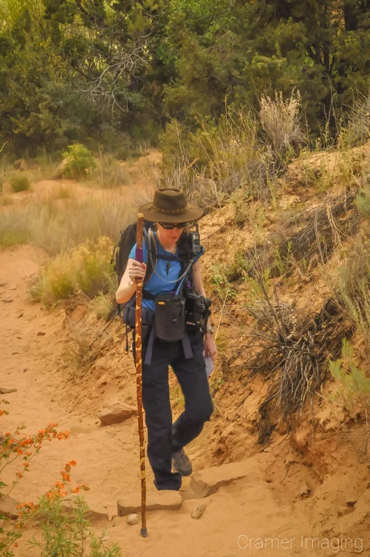 Landscape photographer Audrey Cramer stepping up on a hiking trail in springtime