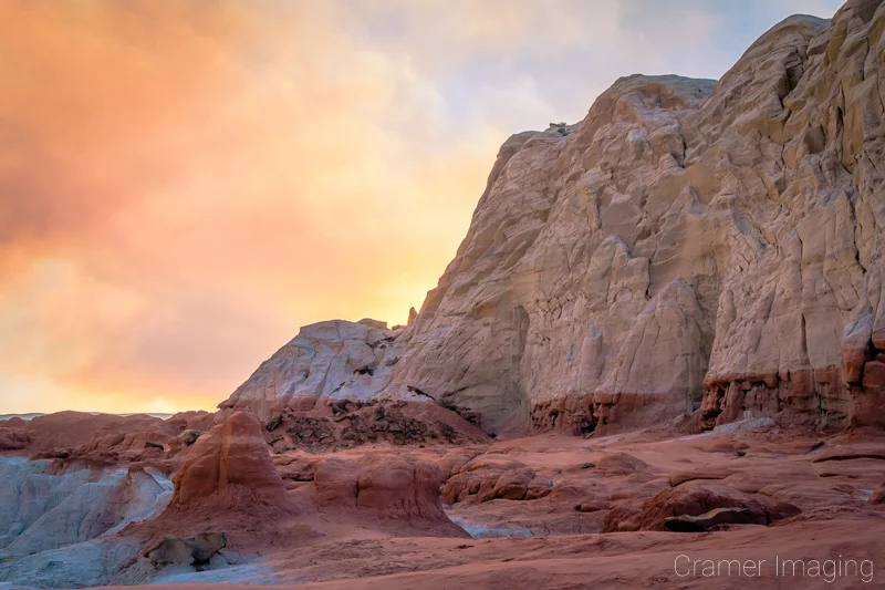 Audrey Cramer Photography's fine art landscape photograph of orange smoke in the sky over the red and white cliffs of Escalante National Monument, Utah