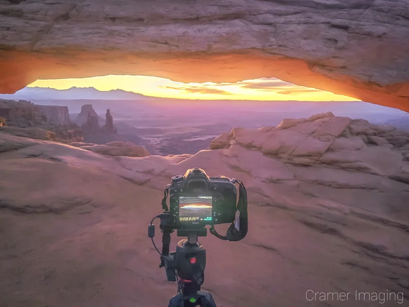 Audrey Cramer Photography's photograph of a camera on a tripod taking a Mesa Arch photo at Canyonlands National Park, Utah