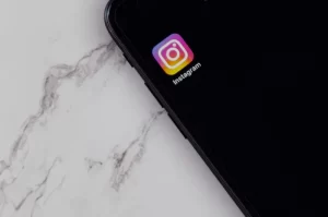 Photo of the Instagram app on a smart phone sitting on a marbled surface