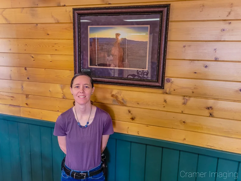 Photo of landscape photographer Audrey Cramer and her photo titled "Forged" on the wall at the Backroads Bistro in Panguitch, Utah