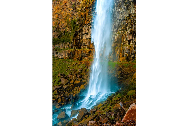 Audrey Cramer Photography's fine art landscape photograph of a waterfall cascading down in a canyon onto rocks in Twin Falls Idaho