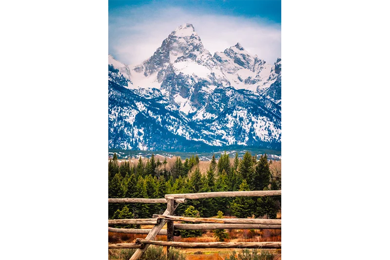 Fine art landscape photograph of a rustic wooden fence against the Grand Teton of Grand Teton National Park Wyoming by Audrey Cramer Photography