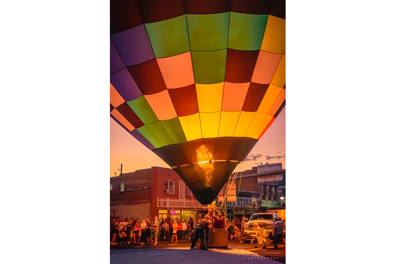 Audrey Cramer Photography's fine art photograph of the Panguitch Utah hot air balloon glow on main street with a jet of fire showing