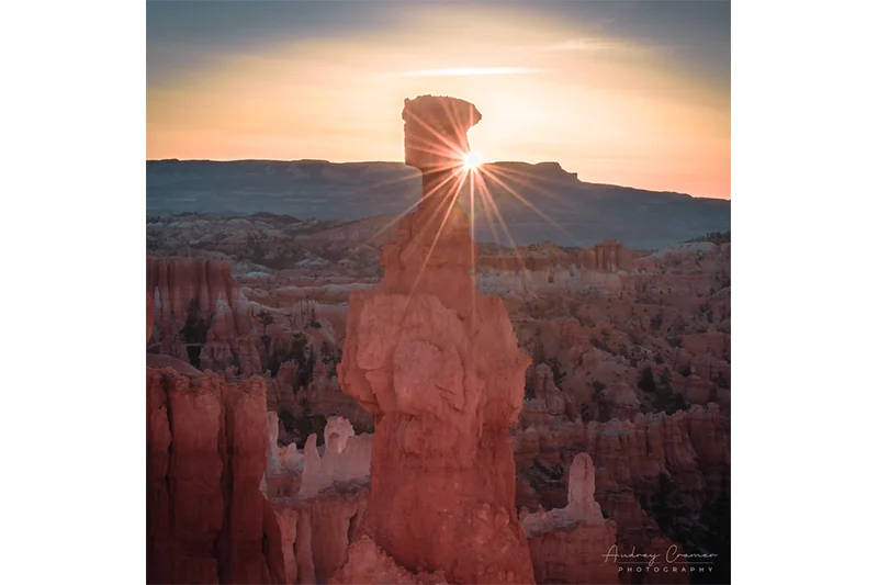 Audrey Cramer Photography's fine art landscape photograph of the sun peeking around the Thor's Hammer hoodoo in Bryce Canyon National Park, Utah