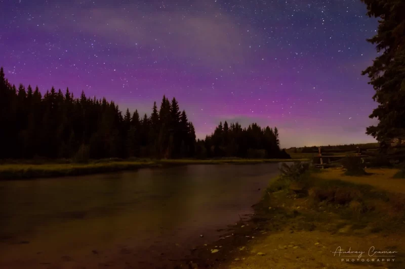 Audrey Cramer Photography's fine art landscape photograph of a faint purple Aurora Borealis appearing in the night skies over Grand Teton National Park, Wyoming